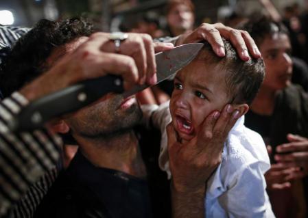 A Shi'ite Muslim has his child gashed with a knife during a Muharram procession ahead of Ashoura in Mumbai, November 3, 2014. REUTERS/Danish Siddiqui