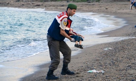 A Turkish police officer carries a young boy who drowned in a failed attempt to sail to the Greek island of Kos. Photograph: Reuters